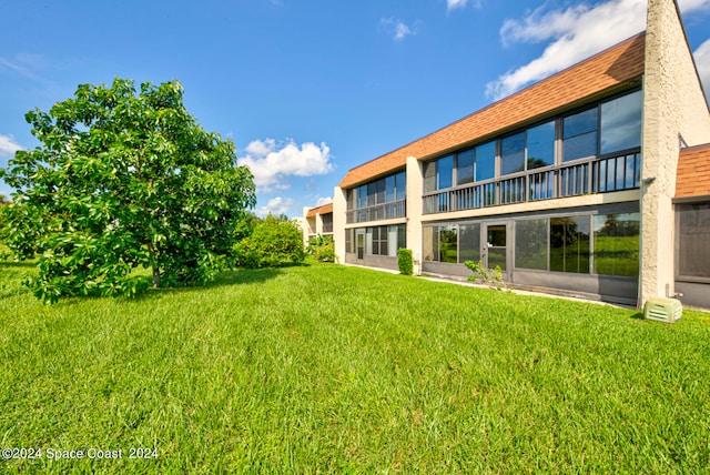 rear view of property featuring a lawn