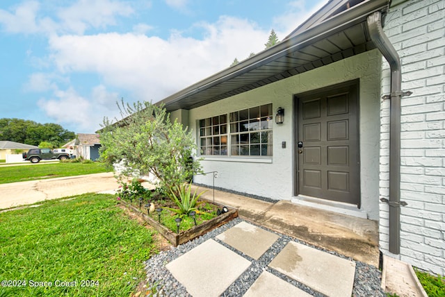 doorway to property with a yard