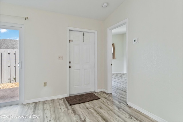 entrance foyer with vaulted ceiling and light hardwood / wood-style floors