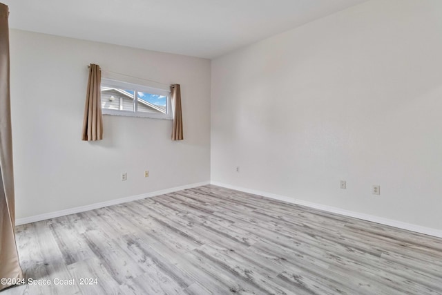 empty room with lofted ceiling and light hardwood / wood-style floors