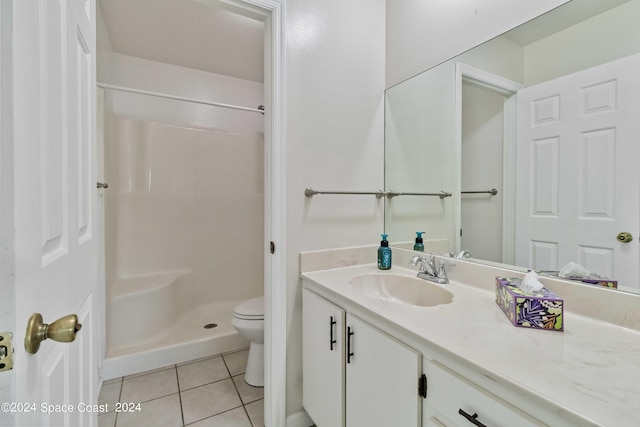 bathroom featuring walk in shower, vanity, tile patterned flooring, and toilet