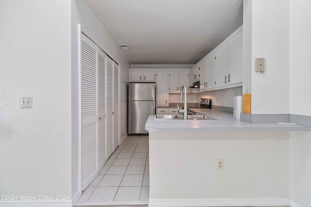 kitchen featuring light tile patterned flooring, sink, white cabinets, kitchen peninsula, and stainless steel fridge