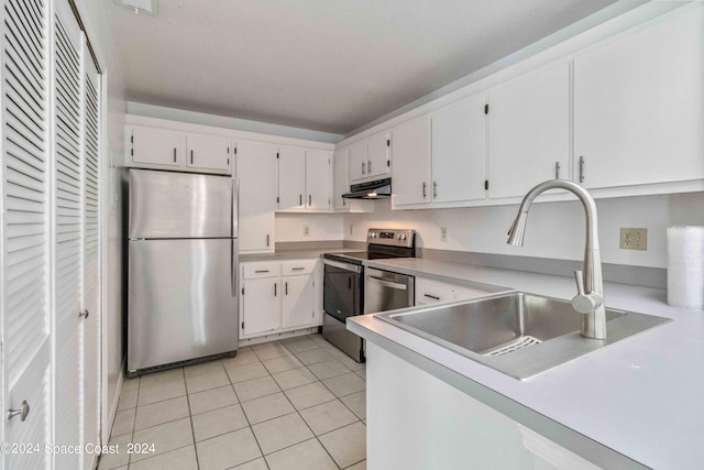 kitchen featuring stainless steel appliances, white cabinetry, light tile patterned flooring, and sink