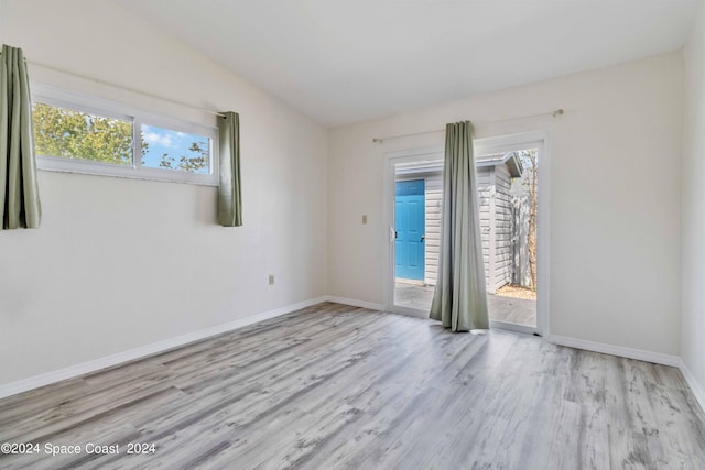 unfurnished room featuring light hardwood / wood-style floors and lofted ceiling