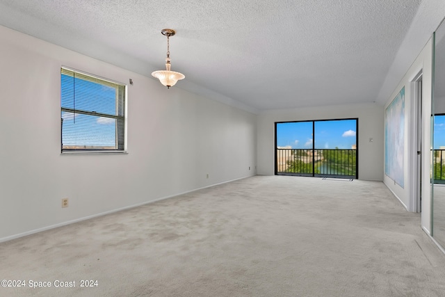 carpeted spare room featuring a textured ceiling