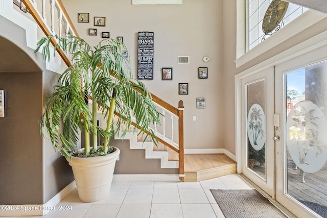 foyer entrance with light tile patterned flooring and french doors