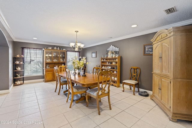 dining area featuring a textured ceiling, light tile patterned flooring, ornamental molding, and an inviting chandelier