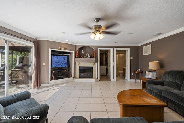 living room with ceiling fan, a textured ceiling, crown molding, and light tile patterned floors