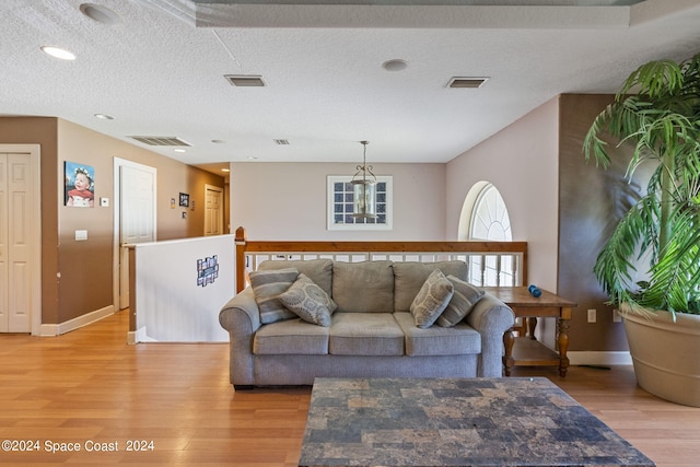 living room with light wood-type flooring and a textured ceiling