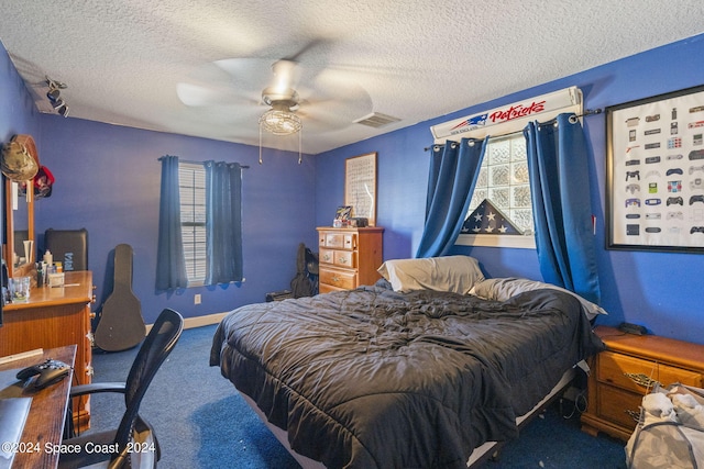 bedroom featuring ceiling fan, carpet floors, and a textured ceiling