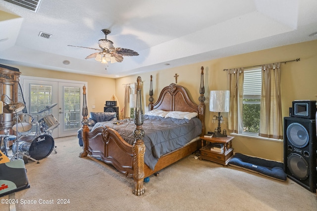 carpeted bedroom featuring ceiling fan, a raised ceiling, french doors, and access to exterior