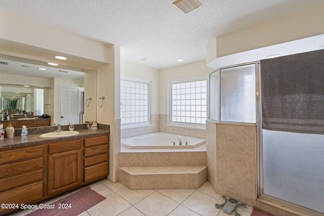 bathroom with a textured ceiling, vanity, separate shower and tub, and tile patterned floors