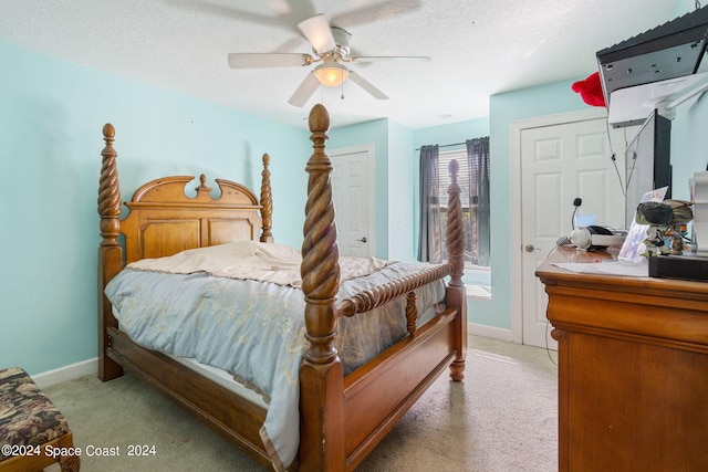 bedroom featuring ceiling fan, a textured ceiling, and light carpet