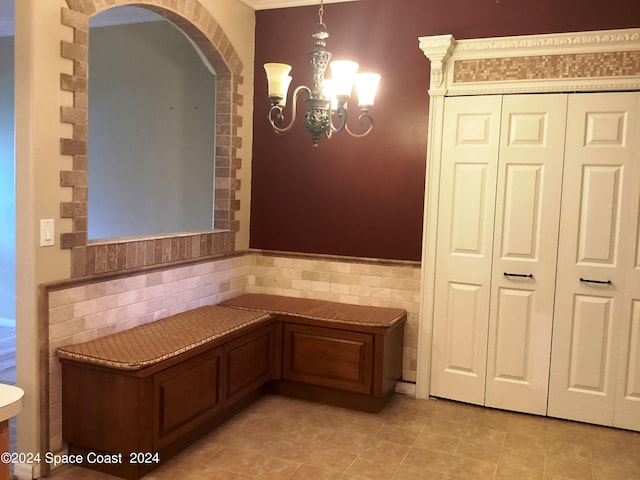 interior space with an inviting chandelier, tile walls, and light tile patterned flooring