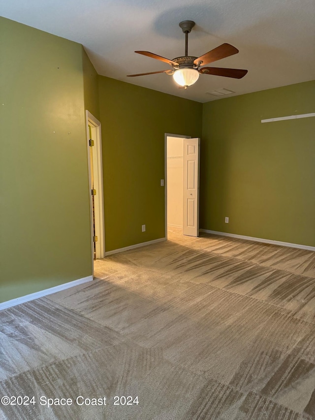 carpeted spare room featuring ceiling fan