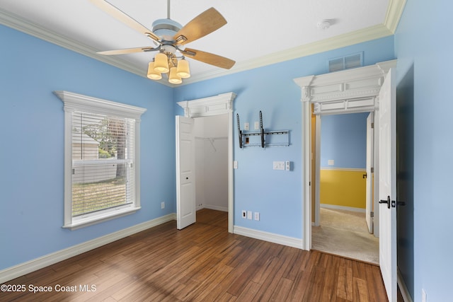 1870 Parrsboro St NW, Palm Bay, FL 32907 - unfurnished bedroom with crown molding, dark wood finished floors, a closet, ceiling fan, and a spacious closet