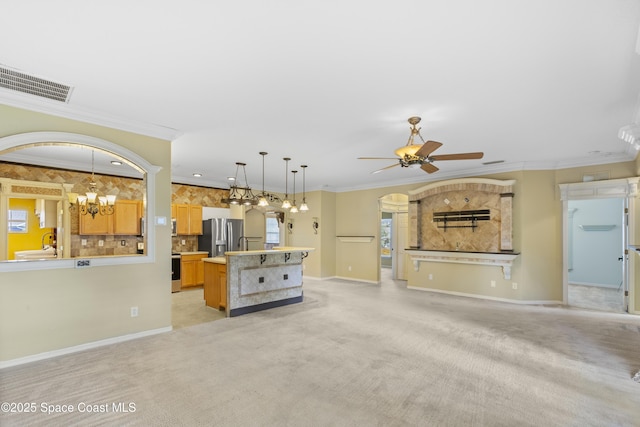 1870 Parrsboro St NW, Palm Bay, FL 32907 - unfurnished living room with a ceiling fan, light carpet, a chandelier, crown molding, and arched walkways