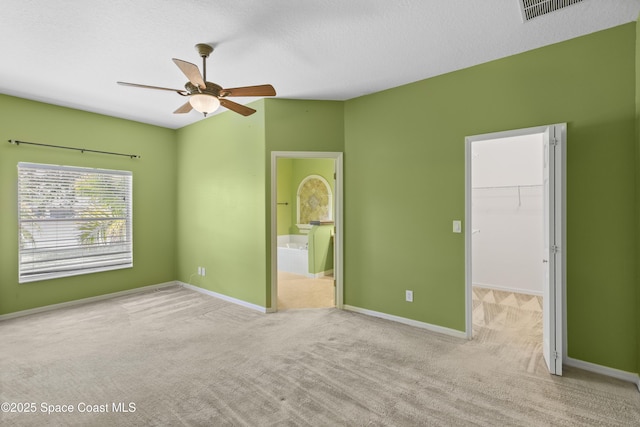 1870 Parrsboro St NW, Palm Bay, FL 32907 - unfurnished bedroom with a spacious closet, carpet, ensuite bath, a closet, and ceiling fan