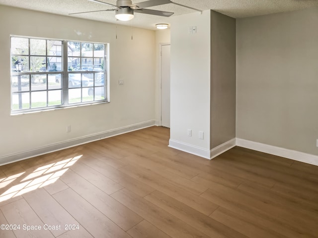 unfurnished room with ceiling fan, light hardwood / wood-style floors, and a textured ceiling