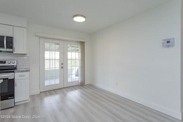 kitchen featuring appliances with stainless steel finishes, light wood-type flooring, french doors, and white cabinets