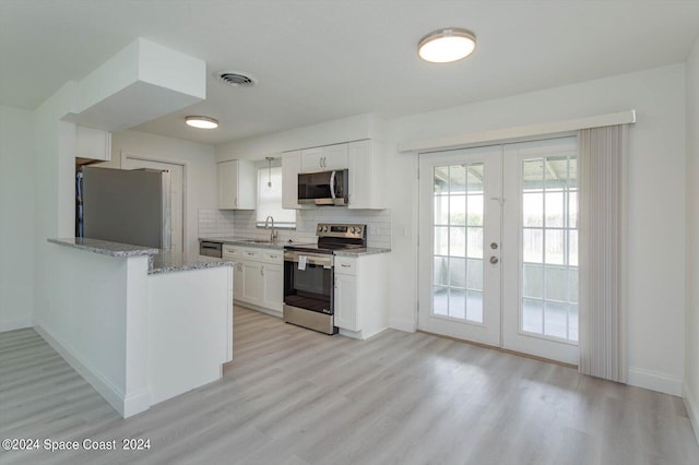 kitchen featuring white cabinets, sink, french doors, stainless steel appliances, and light hardwood / wood-style floors