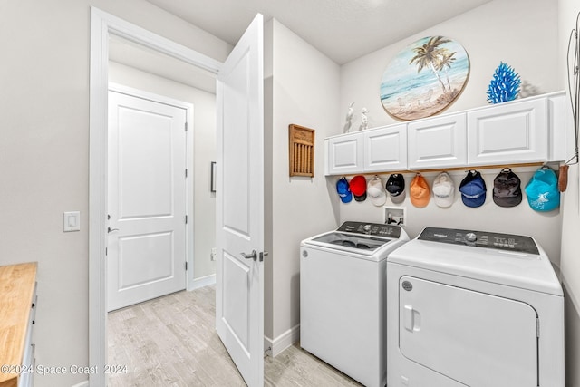 laundry room featuring light wood-type flooring and washing machine and dryer