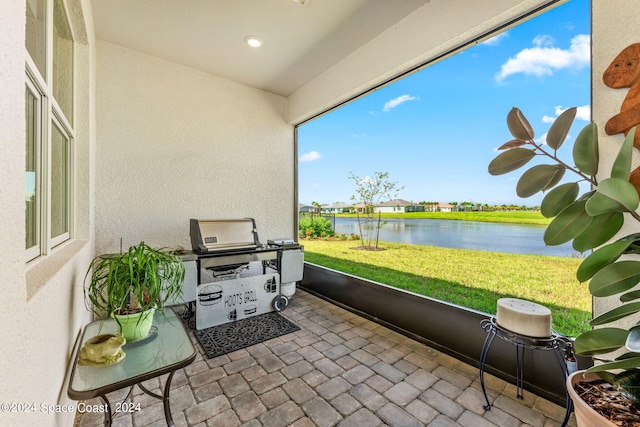 sunroom featuring a water view