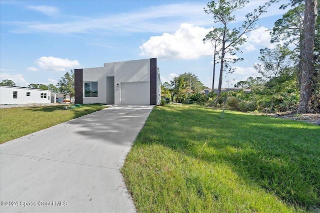 view of front of house with a garage and a front lawn