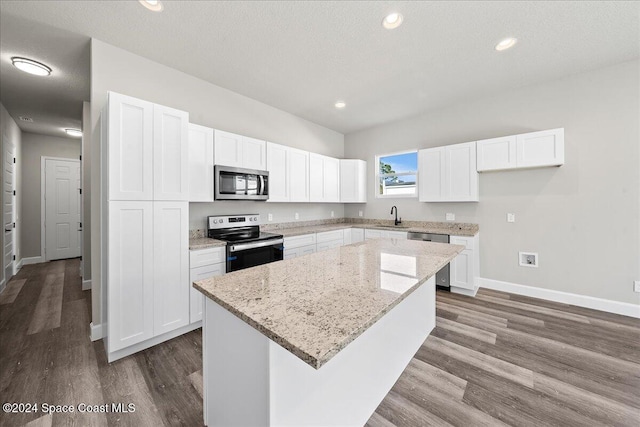 kitchen with white cabinets, a kitchen island, dark hardwood / wood-style flooring, and appliances with stainless steel finishes