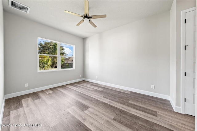 spare room with ceiling fan, light wood-type flooring, and a textured ceiling