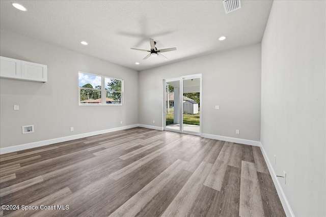 spare room featuring a textured ceiling, light hardwood / wood-style floors, and ceiling fan