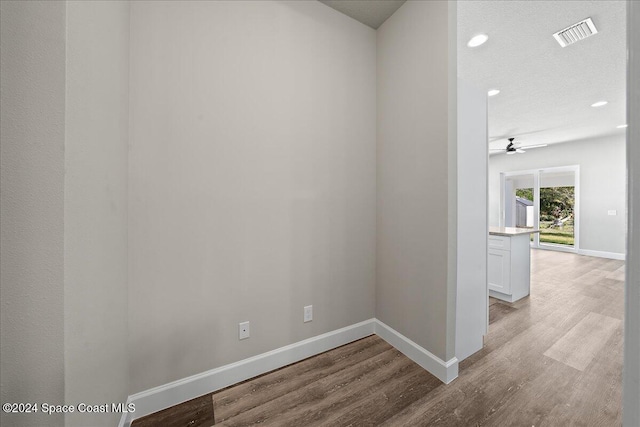 spare room with ceiling fan, light hardwood / wood-style floors, and a textured ceiling