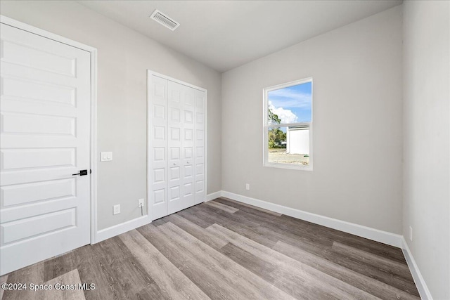 unfurnished bedroom featuring light wood-type flooring and a closet