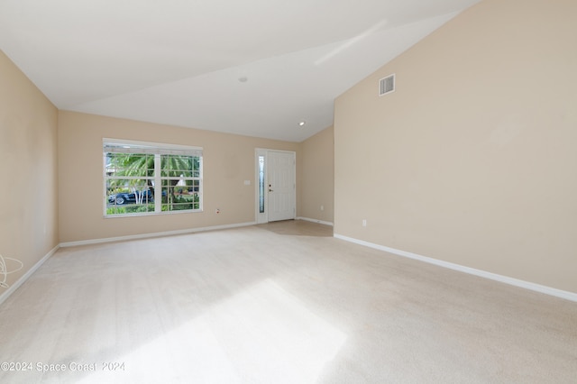 unfurnished room with light carpet and high vaulted ceiling