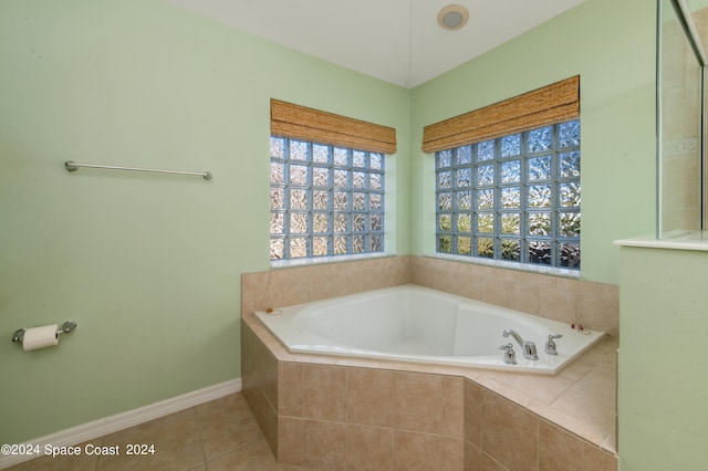 bathroom featuring tile patterned floors and a relaxing tiled tub