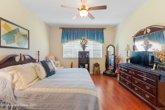 bedroom featuring wood-type flooring, multiple windows, and ceiling fan