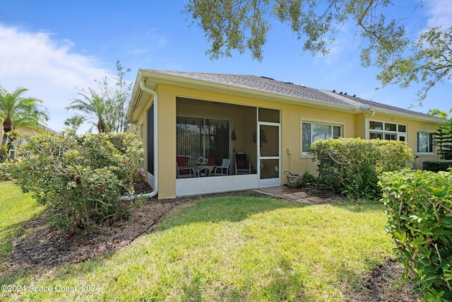 back of house featuring a sunroom and a yard