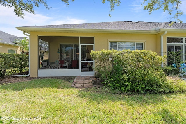 rear view of property featuring a lawn