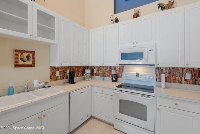 kitchen featuring white cabinets, light tile patterned flooring, sink, white appliances, and backsplash