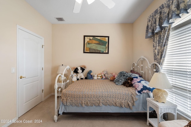 carpeted bedroom with multiple windows and ceiling fan