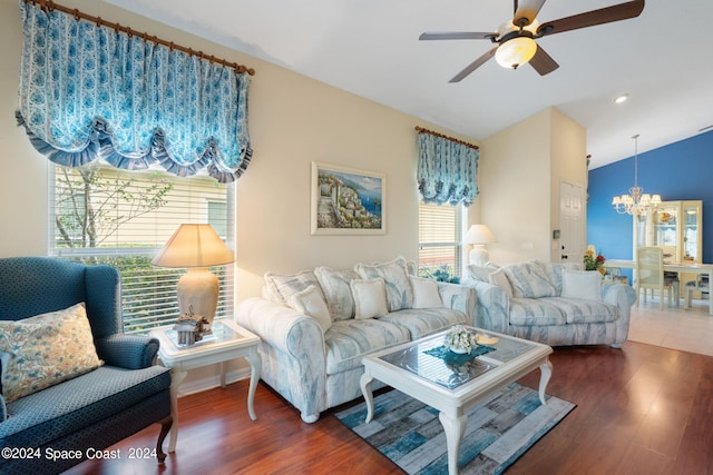 living room with ceiling fan with notable chandelier, dark hardwood / wood-style floors, and lofted ceiling