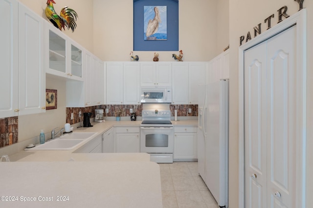 kitchen featuring light tile patterned flooring, sink, white cabinetry, decorative backsplash, and white appliances