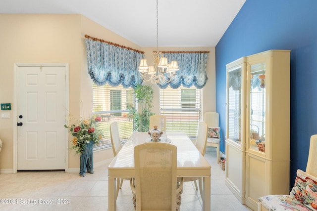 tiled dining space with lofted ceiling and a chandelier