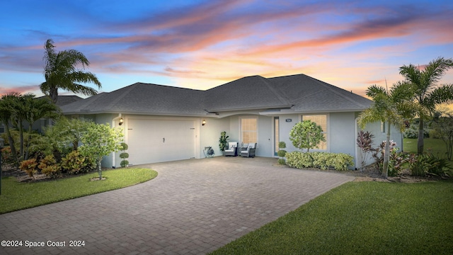 view of front of home featuring a lawn and a garage