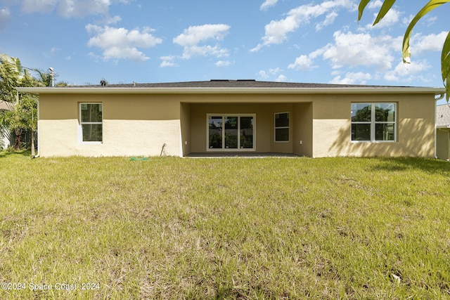 rear view of property featuring a yard