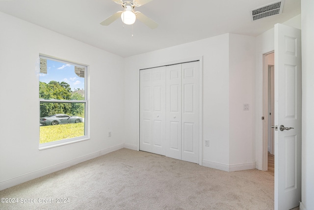 unfurnished bedroom with a closet, ceiling fan, and light colored carpet