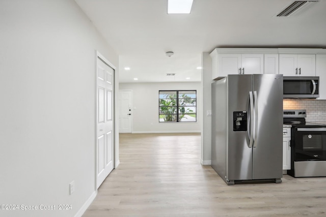 kitchen with light wood-type flooring, decorative backsplash, stainless steel appliances, and white cabinets