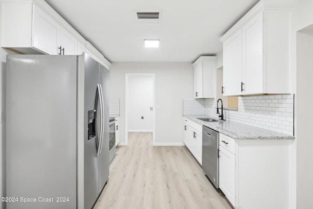 kitchen with light hardwood / wood-style flooring, sink, stainless steel appliances, light stone countertops, and white cabinets