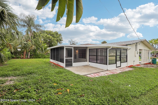 rear view of house featuring a patio, a sunroom, and a lawn