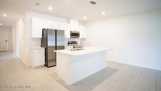 kitchen featuring light countertops, white cabinets, visible vents, stainless steel appliances, and a sink